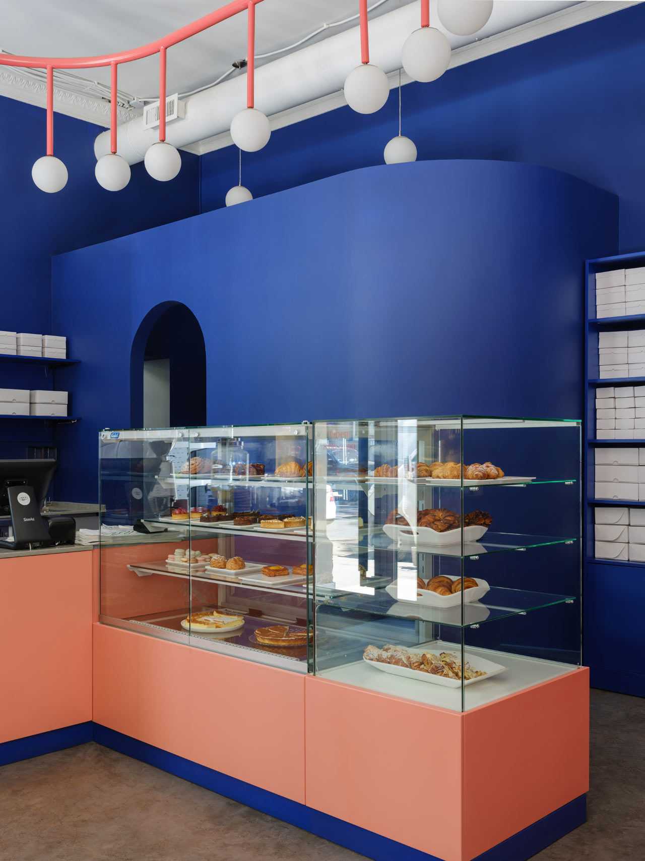 coral bakery case and cashwrap in front of cobalt blue walls