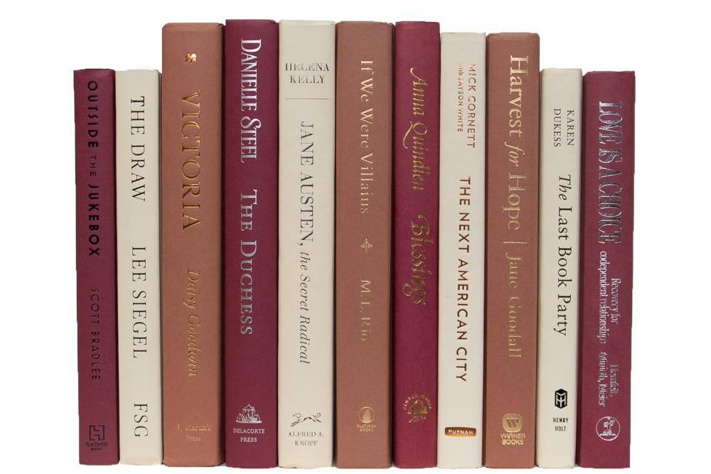 multi-colored decorative books in dark pink, cream, desert